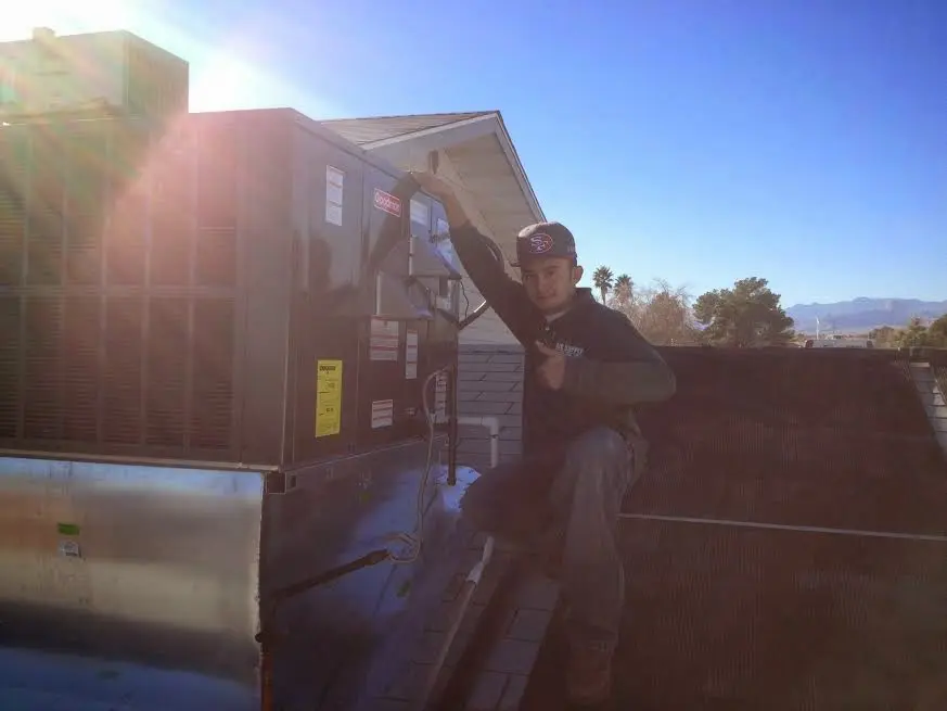 HVAC technician performing AC Tune-Up on a rooftop unit in Linwood